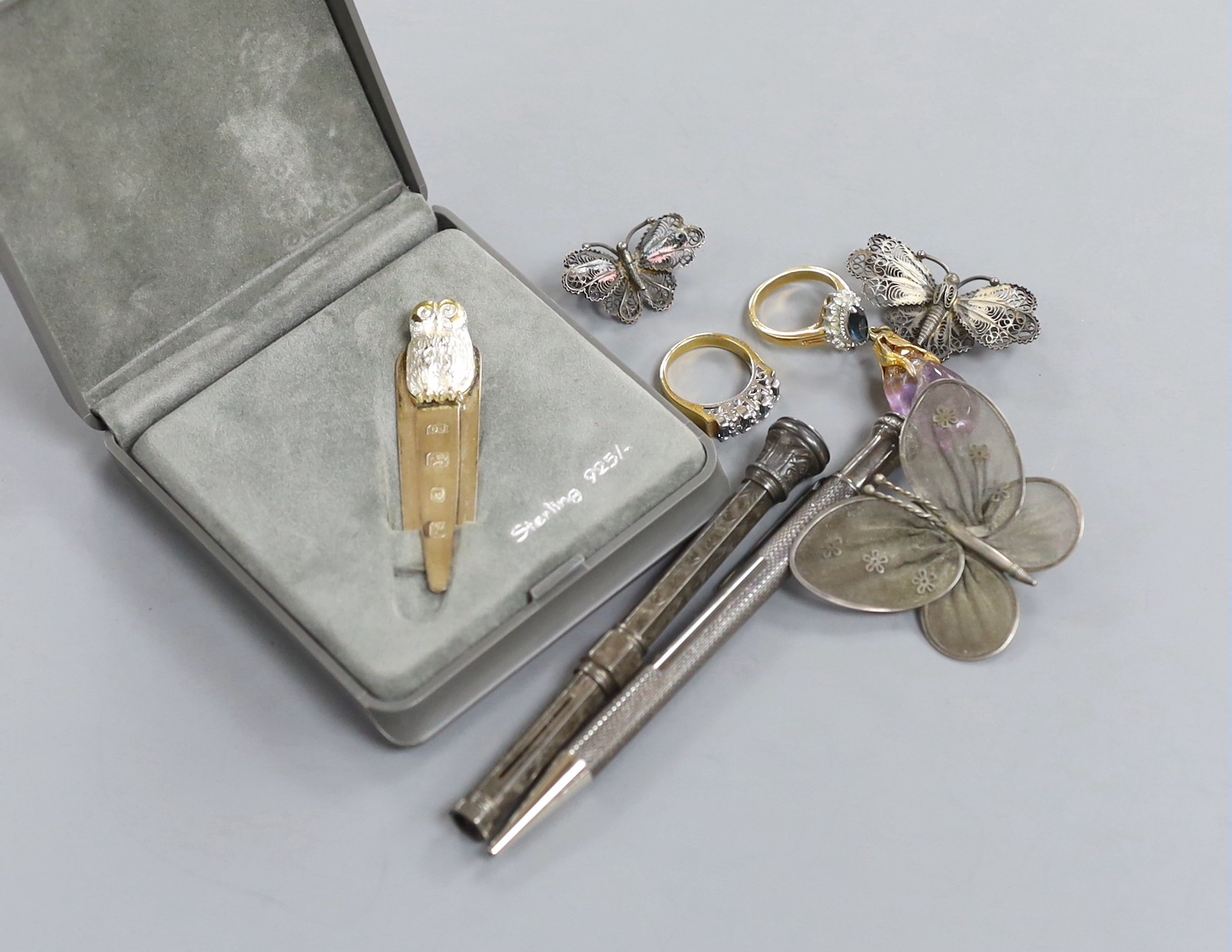 A modern novelty silver owl book mark, by Dix Jewellery Ltd, two Sterling propelling pencils filigree work brooches, various rings and a mounted amethyst pendant.